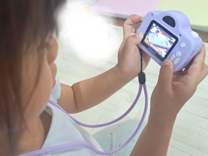 子どもがミニピク（MiNiPiC）を使い、写真を撮っている。