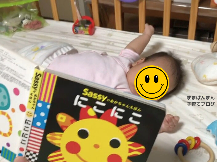 絵本「にこにこ」を読み聞かせてもらっている０歳。