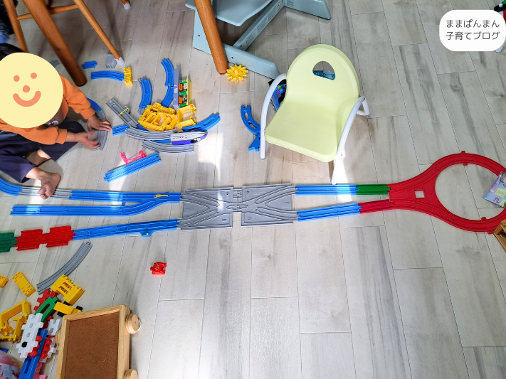 子どもがプラレールを繋げている写真